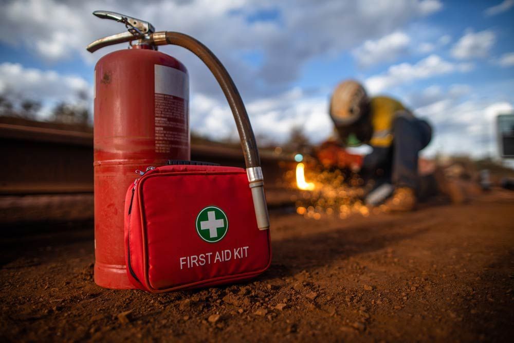 A Fire Extinguisher And A First Aid Kit Are On The Ground — Firewerx In Dubbo, NSW