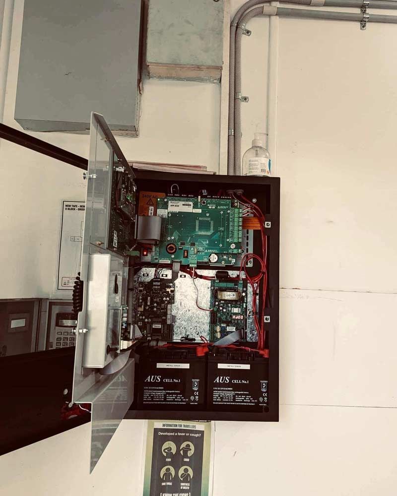 A Security System Is Hanging On A Wall With The Door Open — Firewerx In Orange, NSW