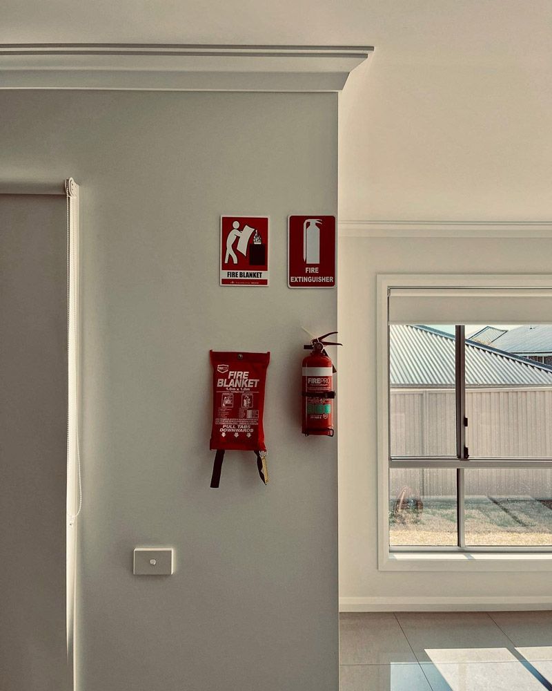 A Fire Extinguisher Is Hanging On A Wall Next To A Fire Blanket — Firewerx In Dubbo, NSW