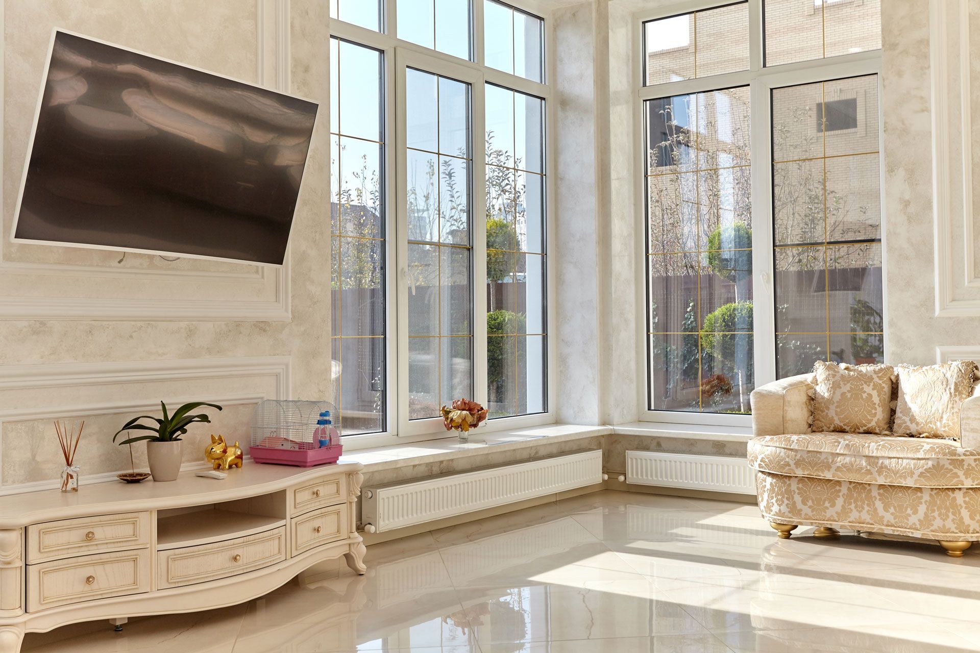 Living room with large windows, cream-colored walls, white trim, and a cream-colored sofa.