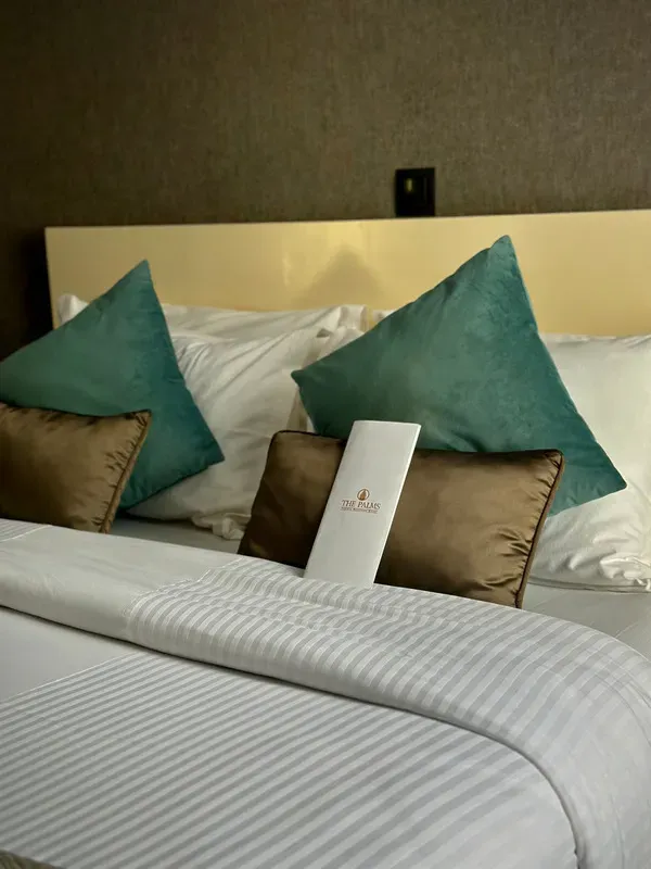 Une chambre d'hôtel avec un lit avec des draps et des oreillers blancs