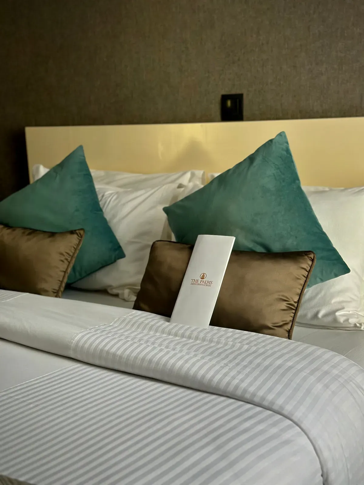 Une chambre d'hôtel avec un lit avec des draps et des oreillers blancs