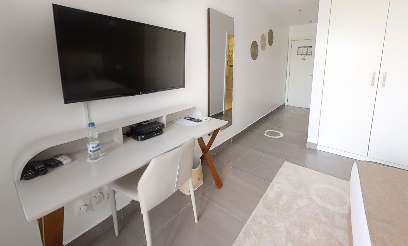 Une chambre d'hôtel avec un bureau et une télévision à écran plat