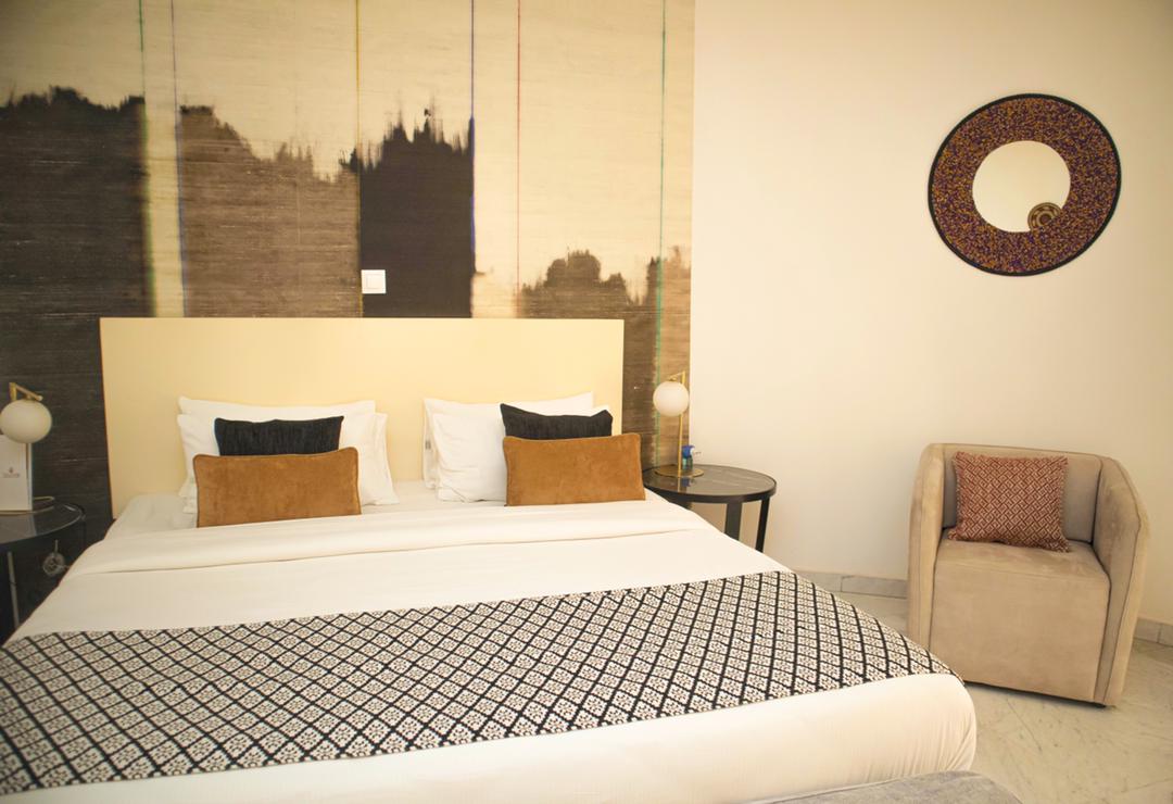 Une chambre avec un lit, une chaise, une table et un tableau au mur.