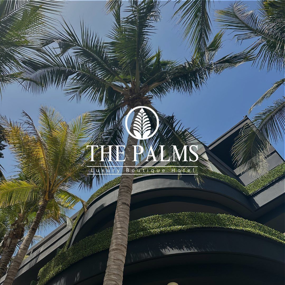 Une photo d'un bâtiment avec des palmiers devant.