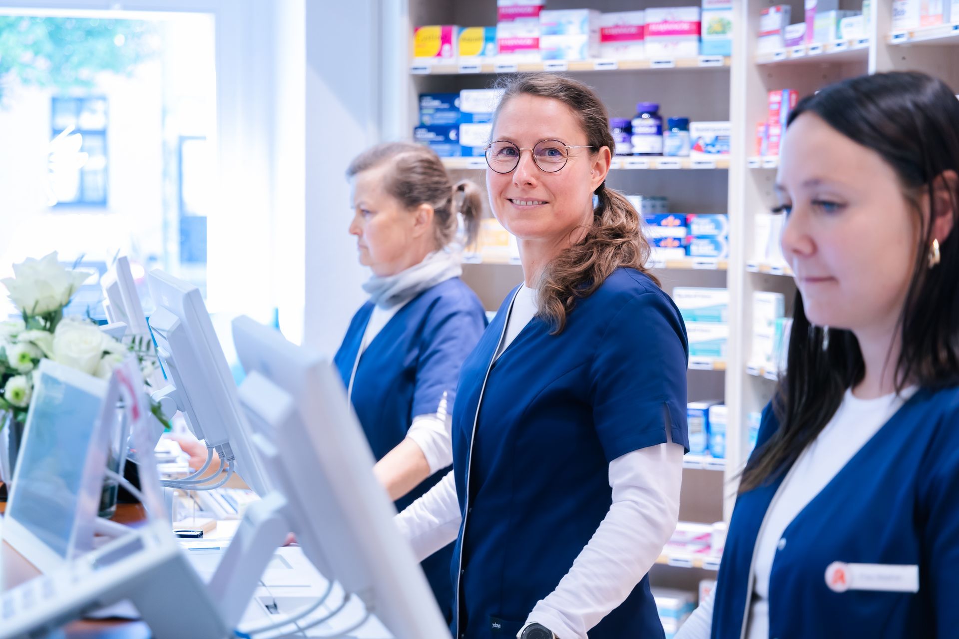 Eine Gruppe von Frauen steht in einer Apotheke vor einem Computer.