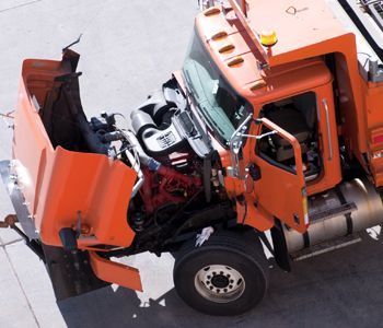 An orange truck with the hood up and the door open