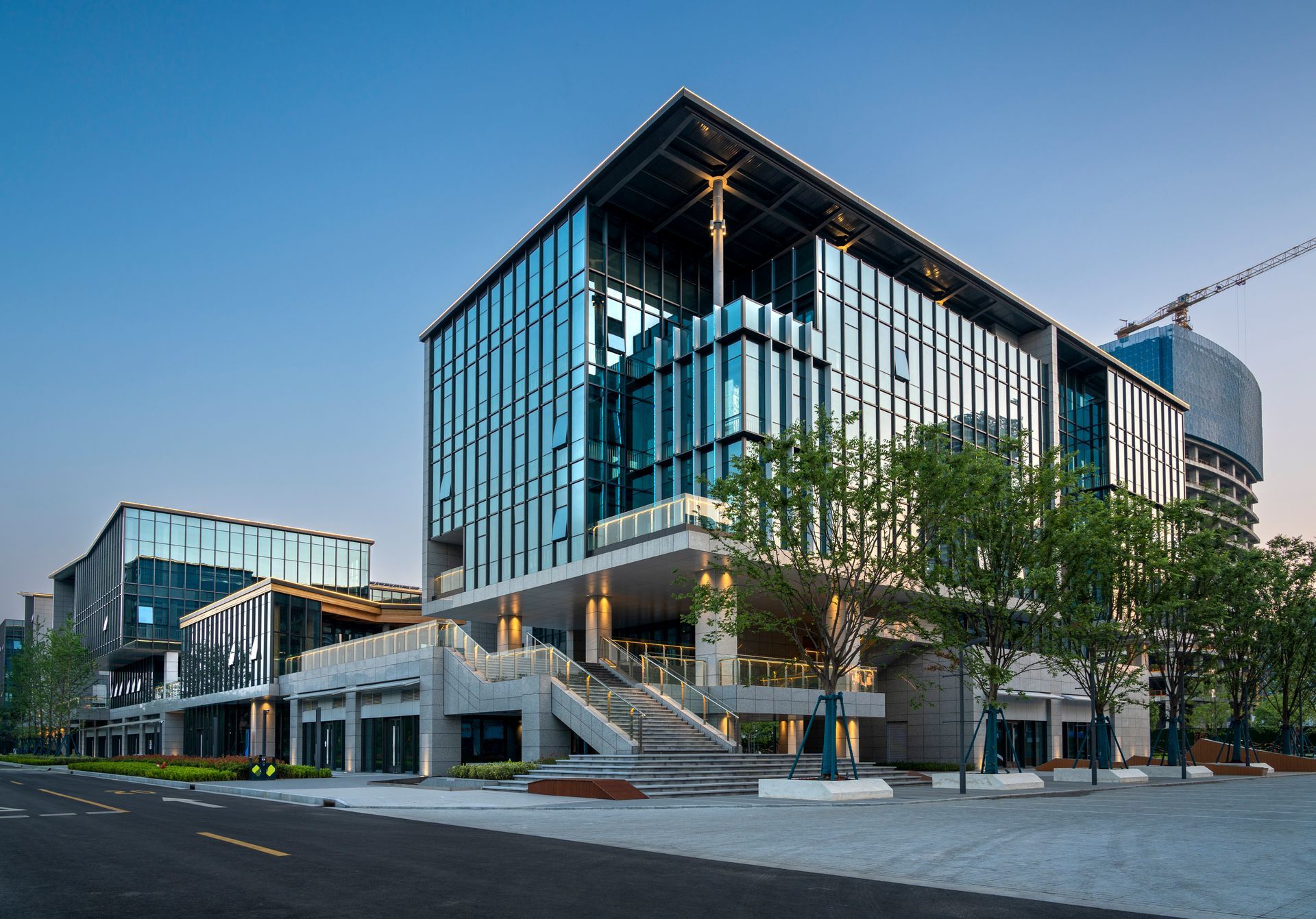 A large building with a lot of windows is sitting next to a street.