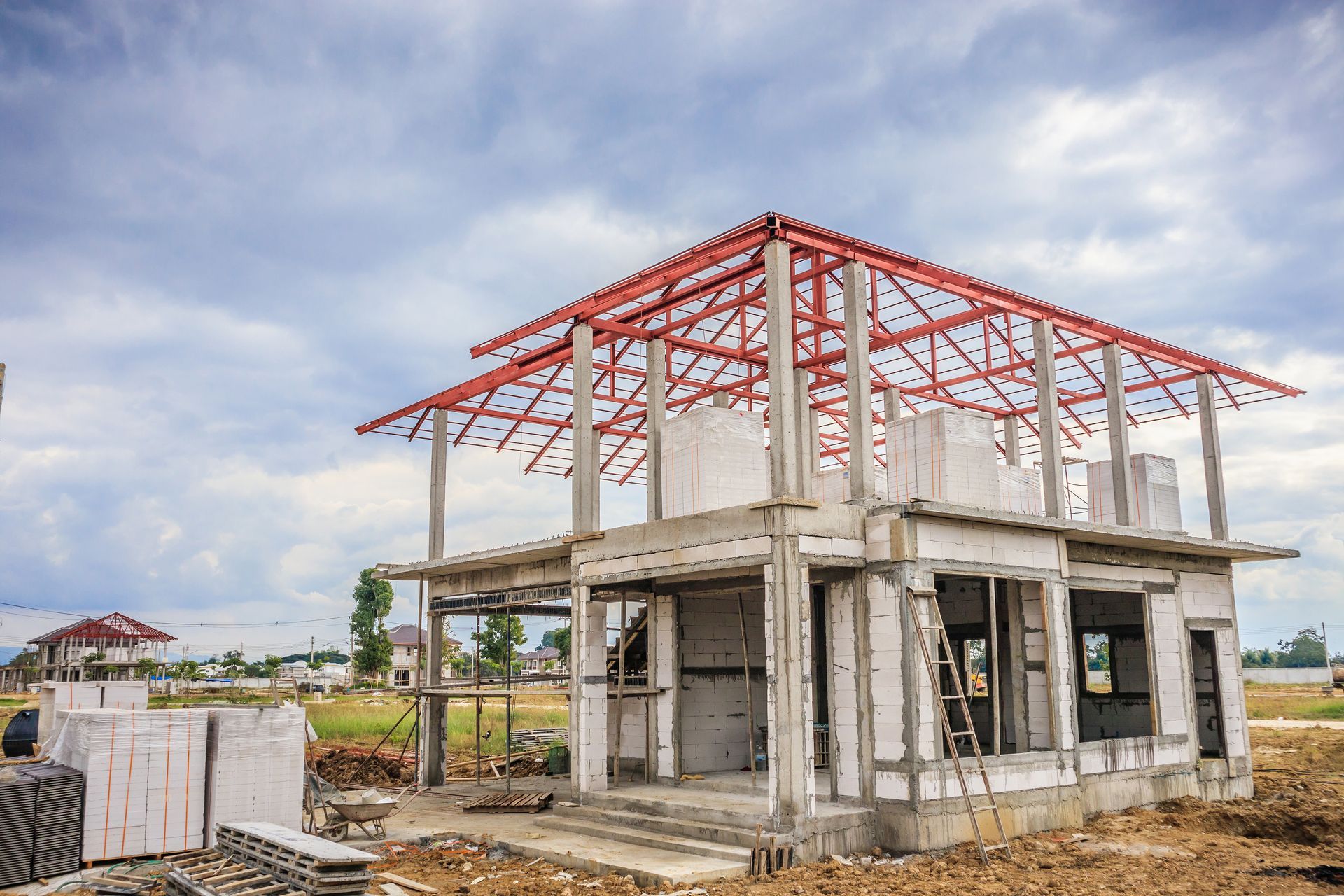 A house is being built with a red roof.