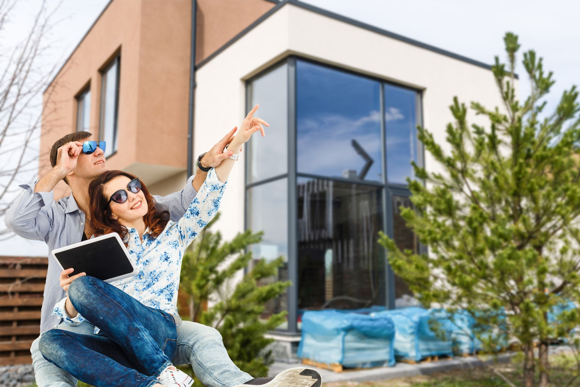 A man and a woman are sitting in front of a house.