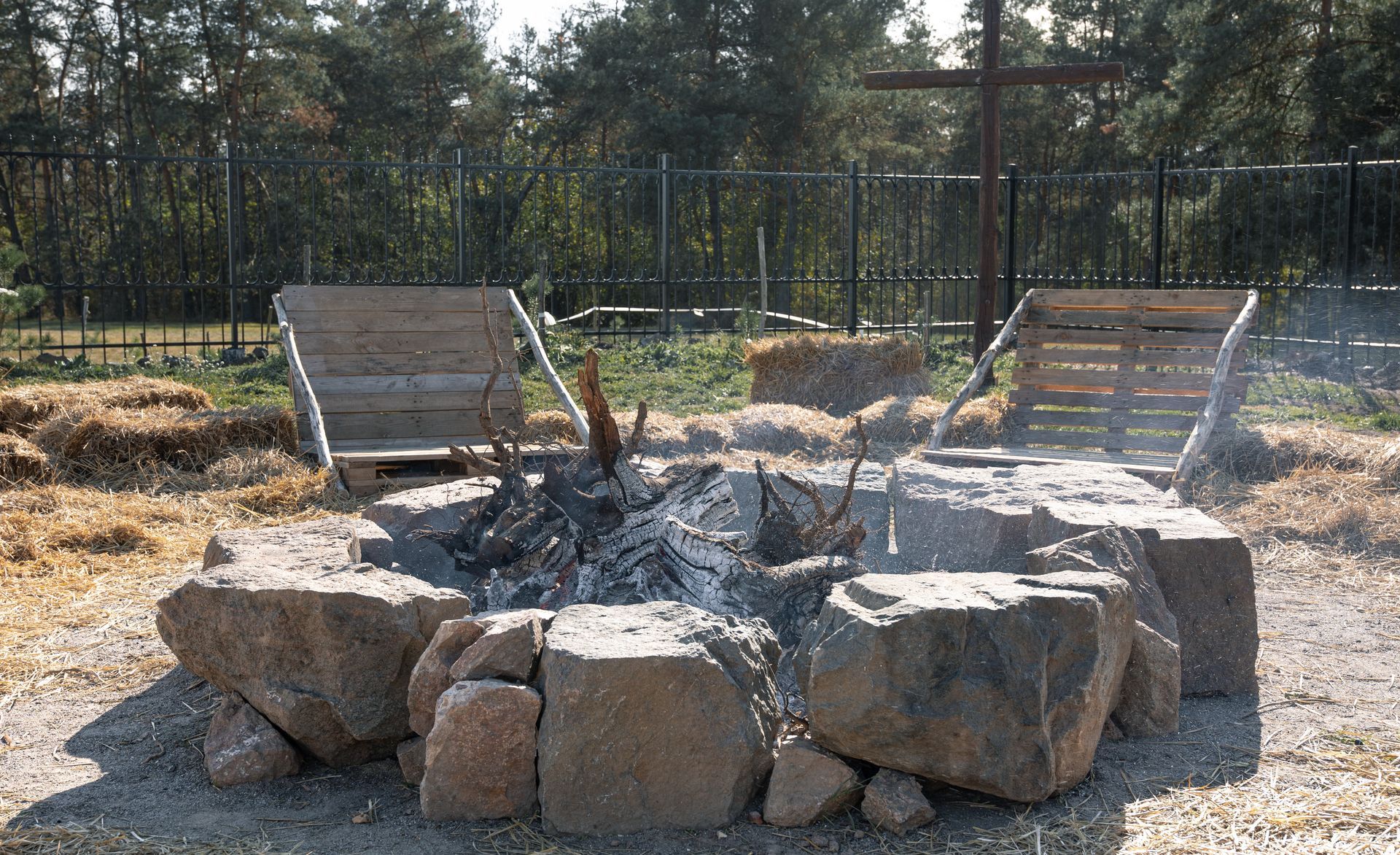 A fire pit with a cross in the background