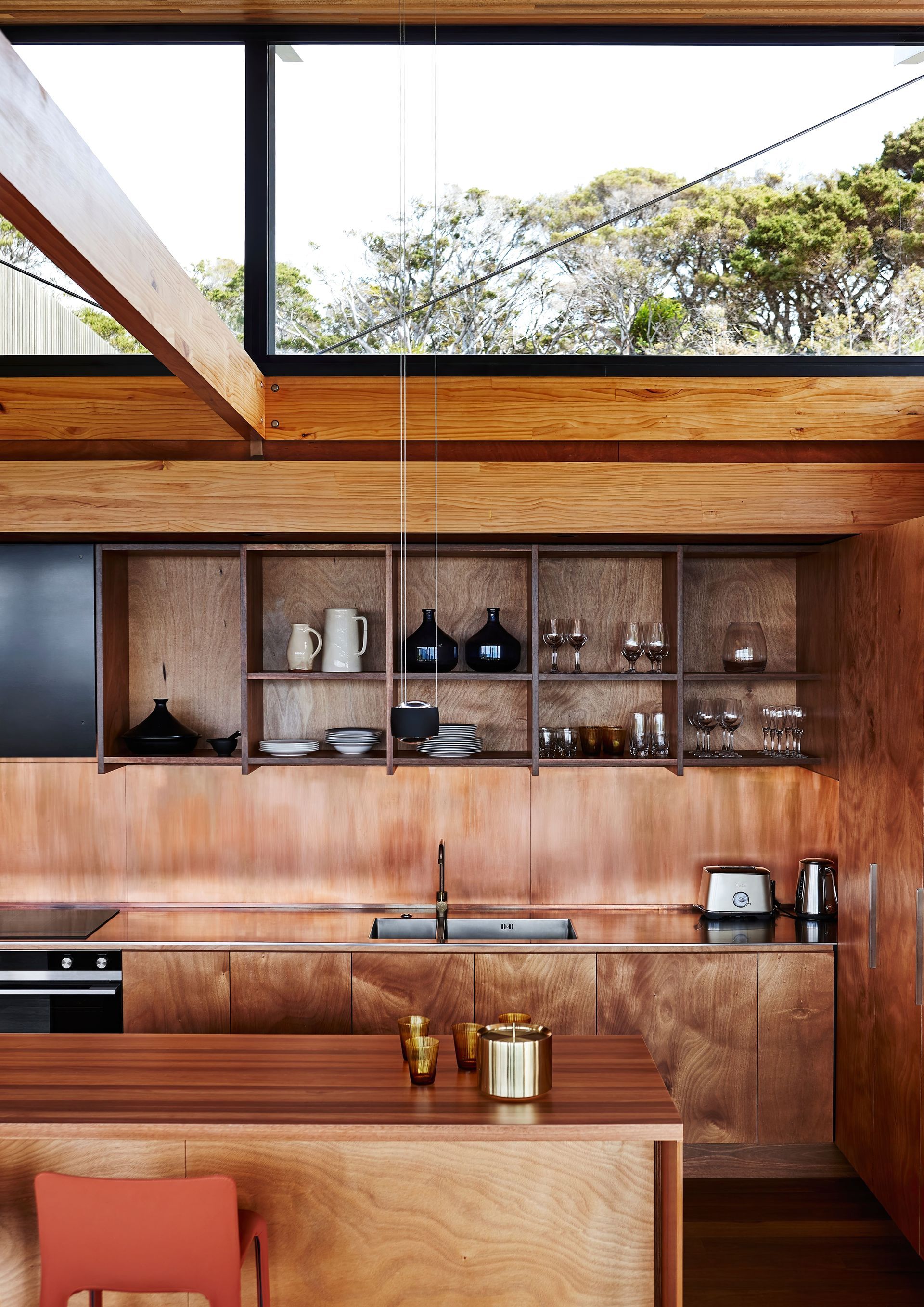 A kitchen with wooden cabinets and a large window