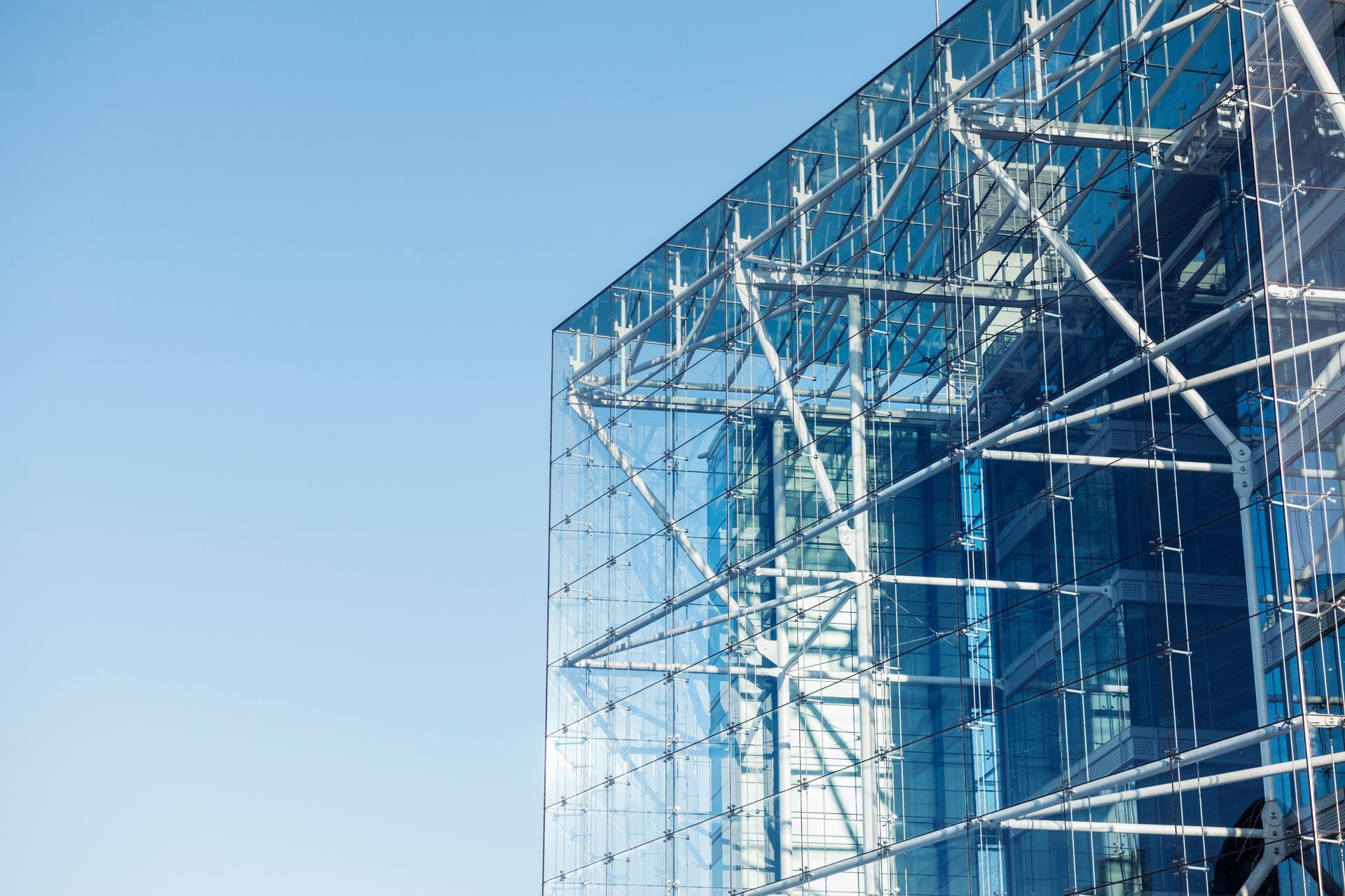 A large glass building with a blue sky in the background.