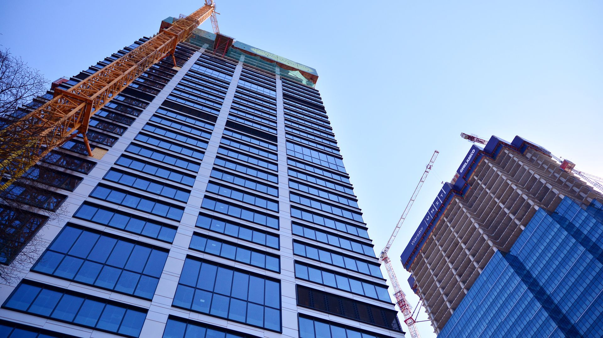 A tall building under construction with a crane in front of it.