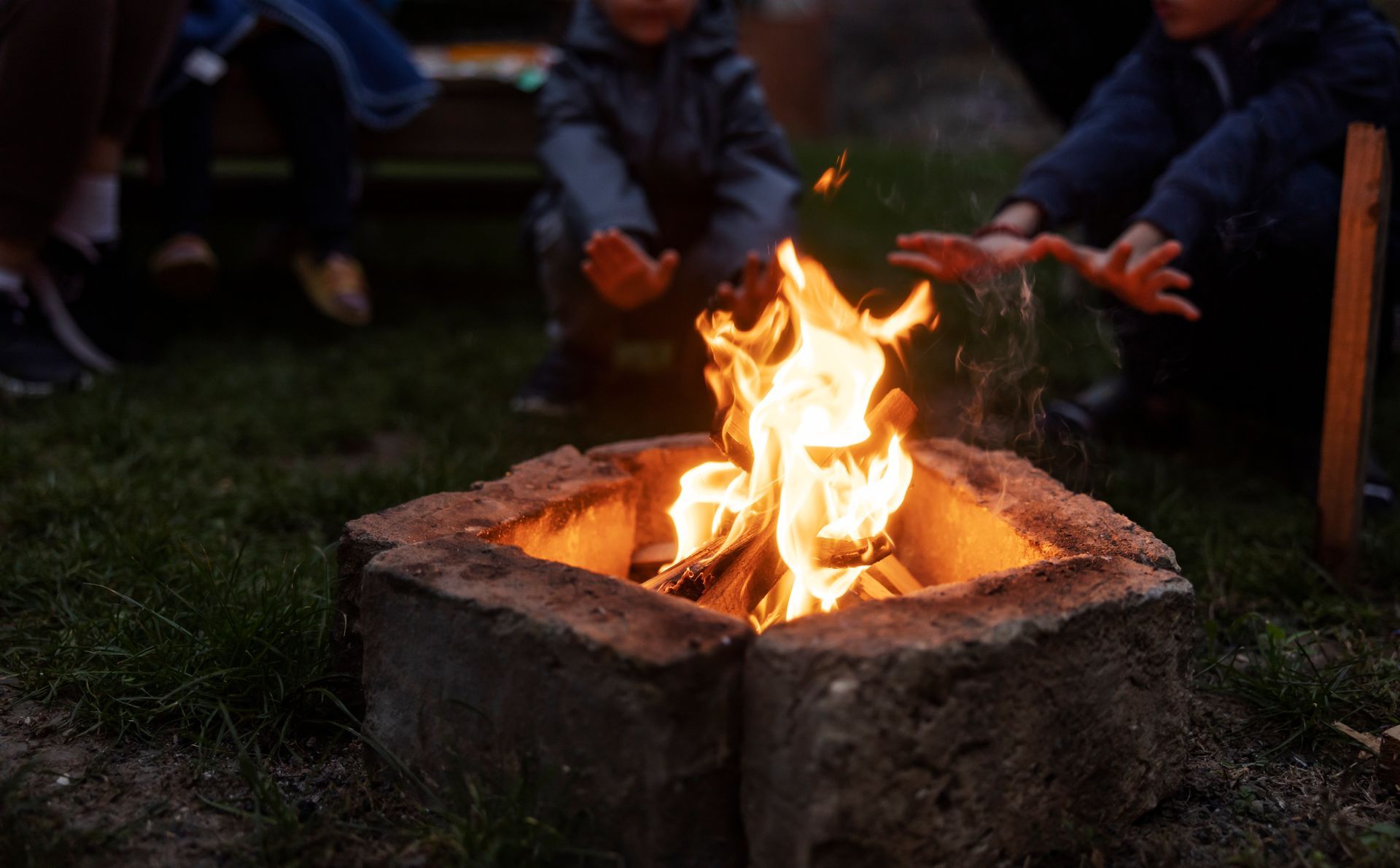 A group of people are sitting around a fire pit.
