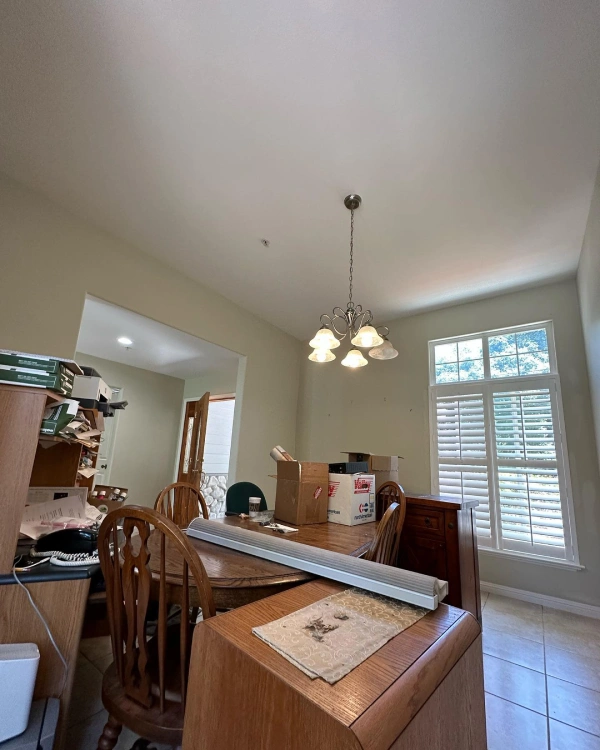A dining room with a table and chairs and a chandelier.
