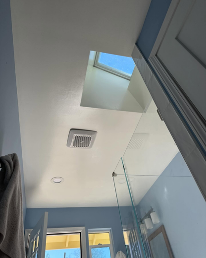 A bathroom with a skylight in the ceiling