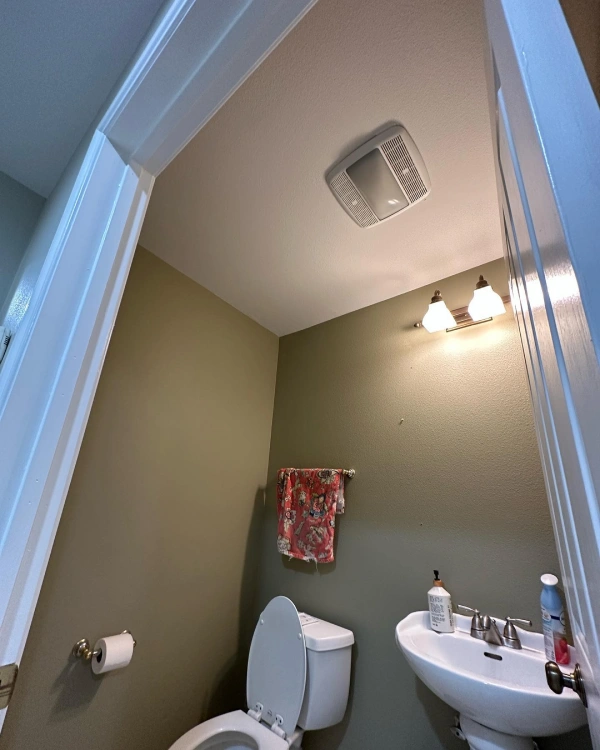 A bathroom with a toilet a sink and a mirror