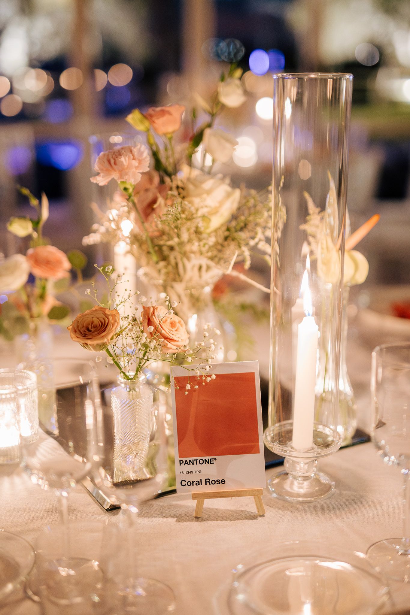 Apparecchiatura della tavola con fiori, candele e biglietti d'auguri, toni caldi, atmosfera intima.