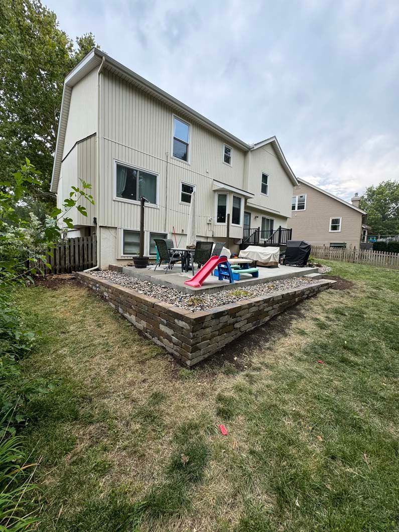 A house with a patio and a slide in the backyard.