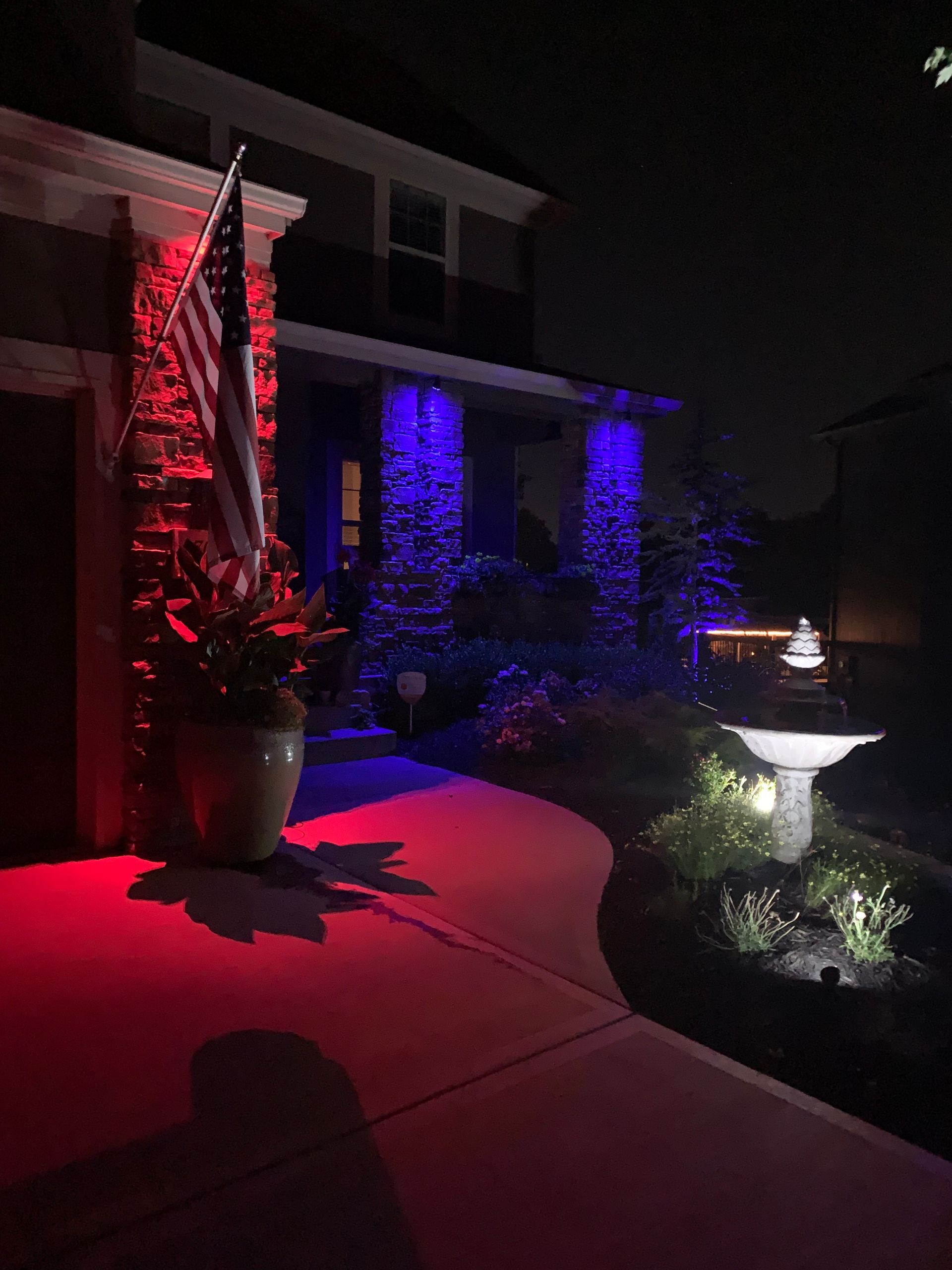 A house is lit up with red and blue lights at night.