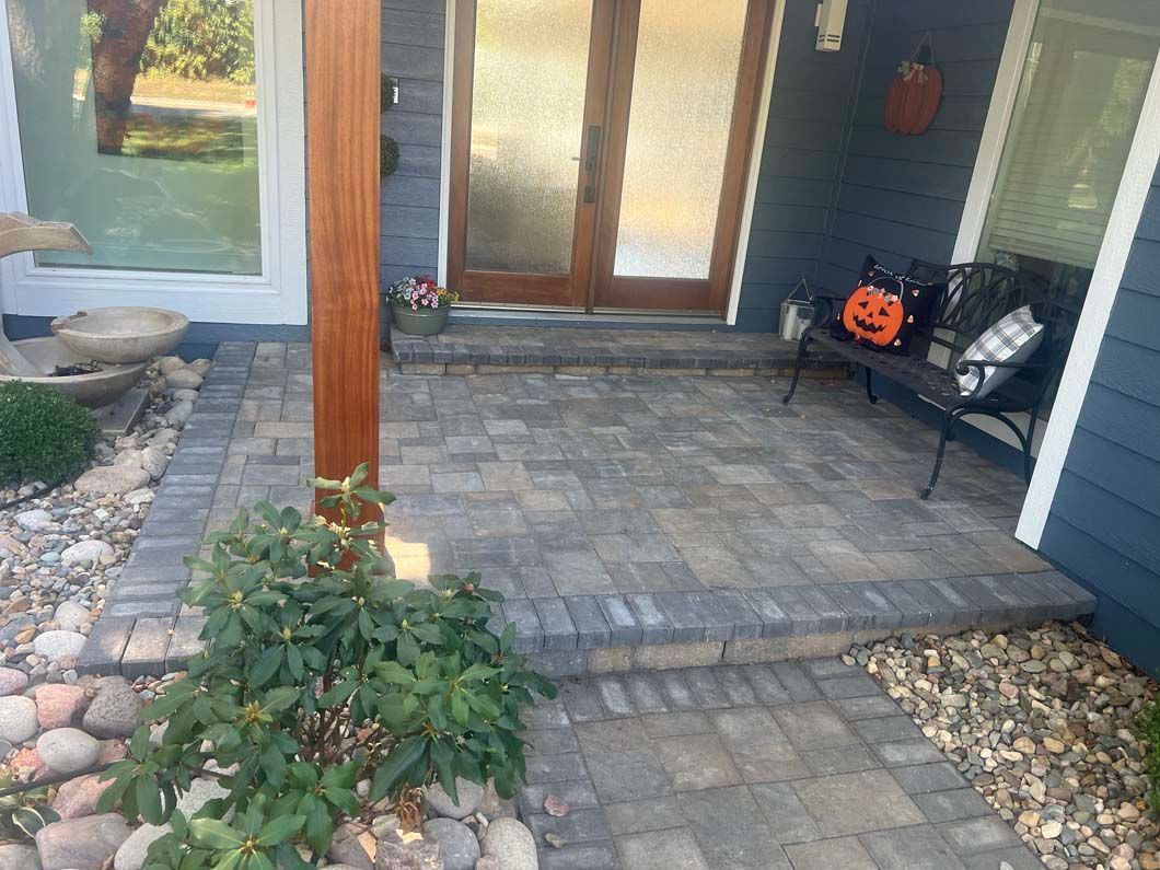 A brick walkway leading to the front door of a house.