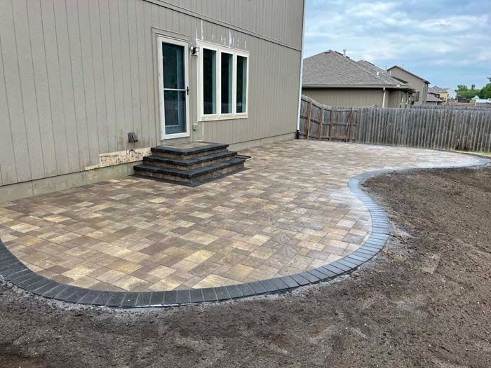 A backyard with a patio and stairs in front of a house.