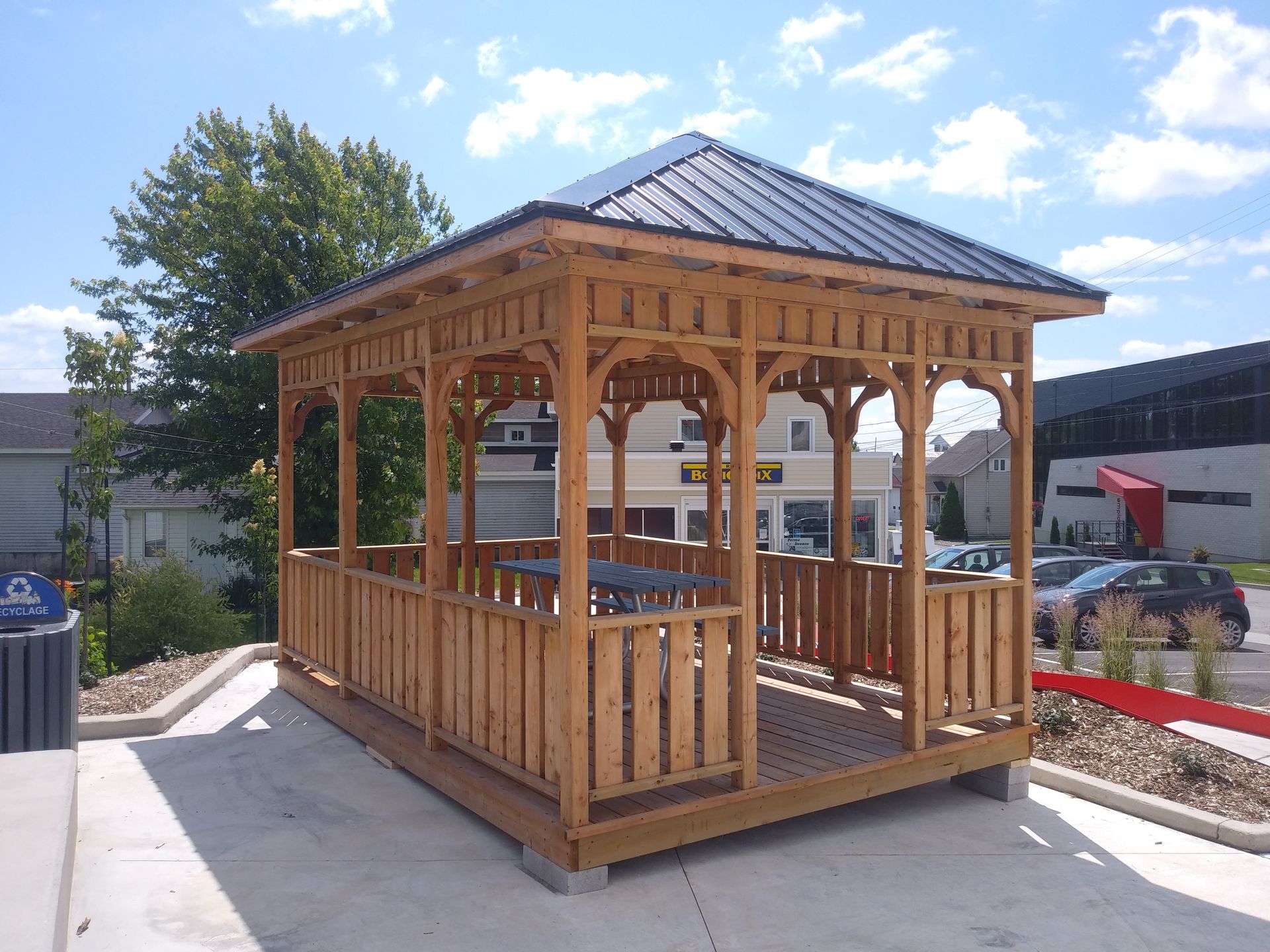 Gazebo en bois avec toit en métal, situé à l'extérieur.