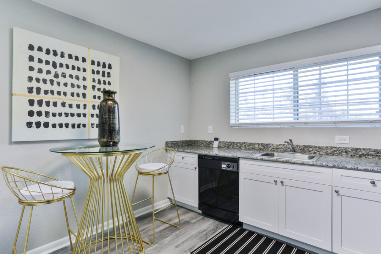 A kitchen with a table and chairs and a window.