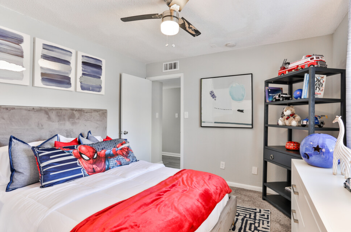 A bedroom with a bed and a ceiling fan.