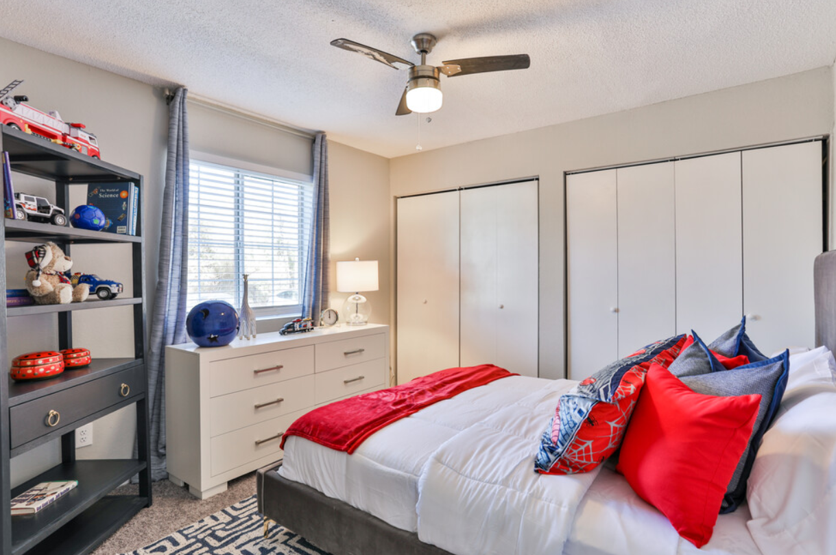 A bedroom with a bed and a ceiling fan