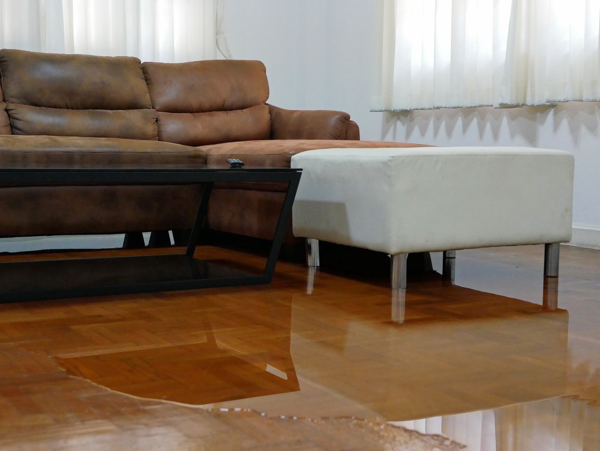 Living room parquet floor with water, showcasing the severe effects of sewage water damage indoors. Living room parquet floor with water, showcasing the severe effects of sewage water damage indoors.