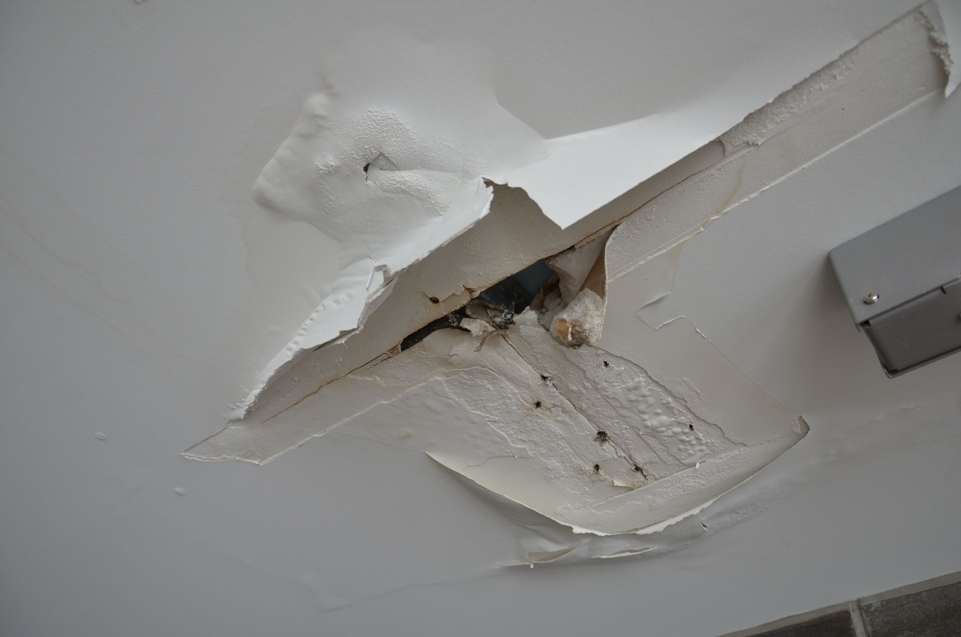 Broken drywall and ceiling in building due to water damage.