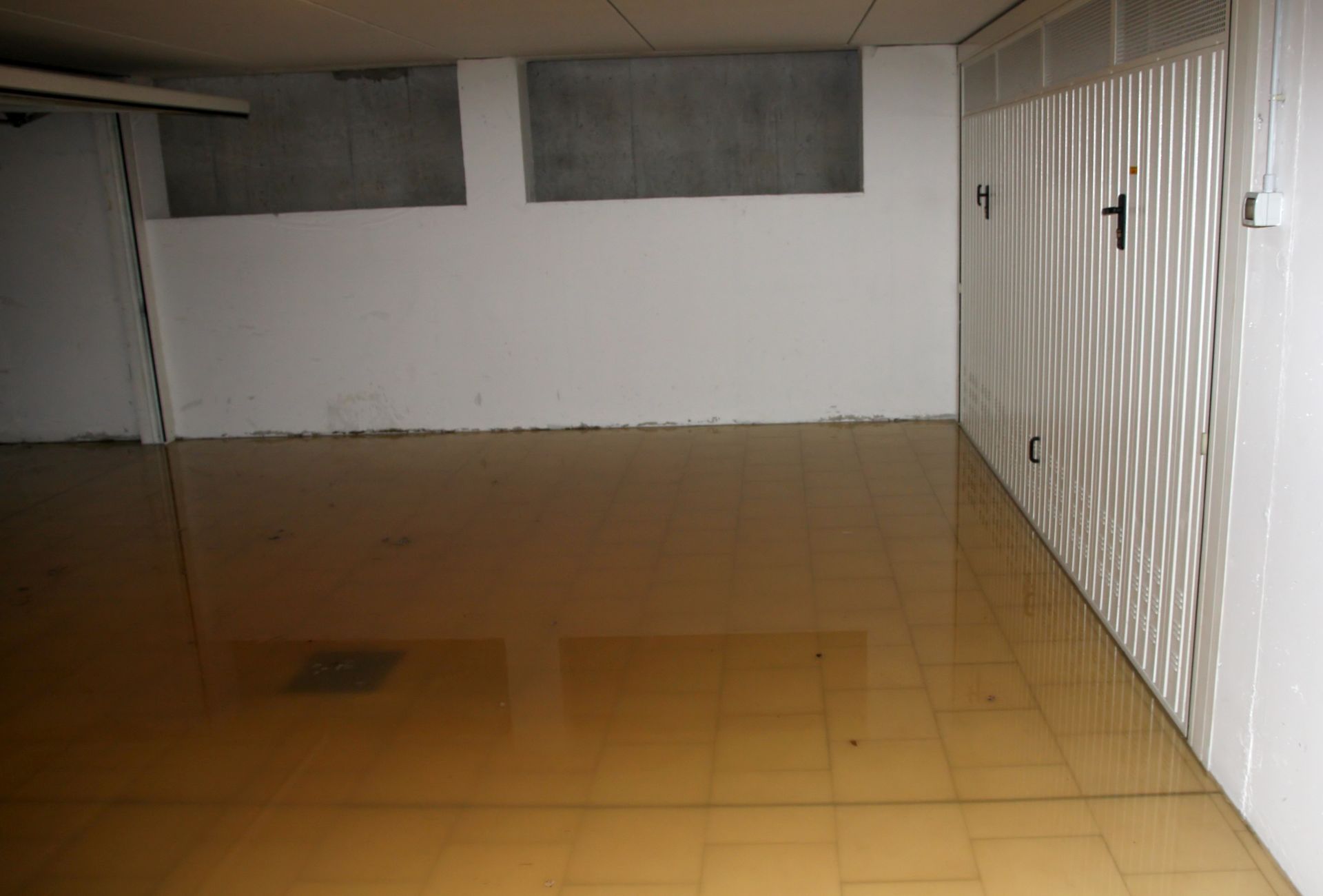 Underground parking area with water accumulation, representing serious sewage water damage issues. Underground parking area with water accumulation, representing serious sewage water damage issues.