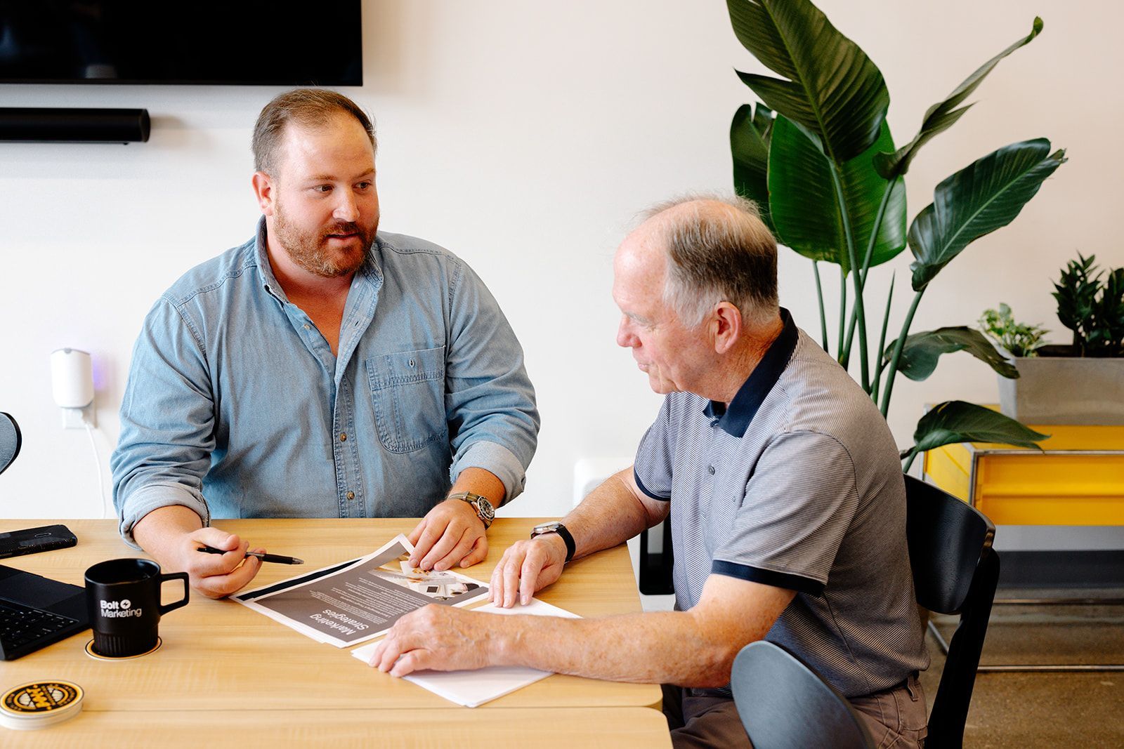 A man and a woman are standing in front of a wall with pictures on it.