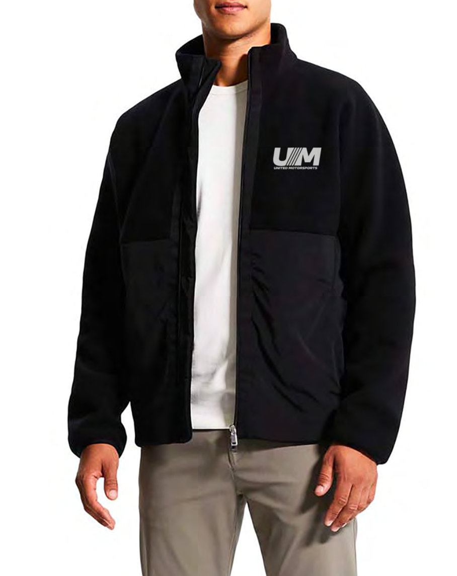 a man wearing a black jacket with the United Motorsports logo on it