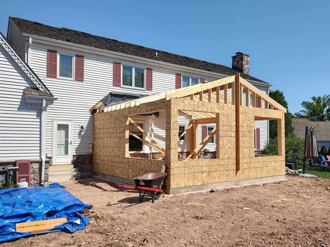 A wooden structure is being built in front of a house.