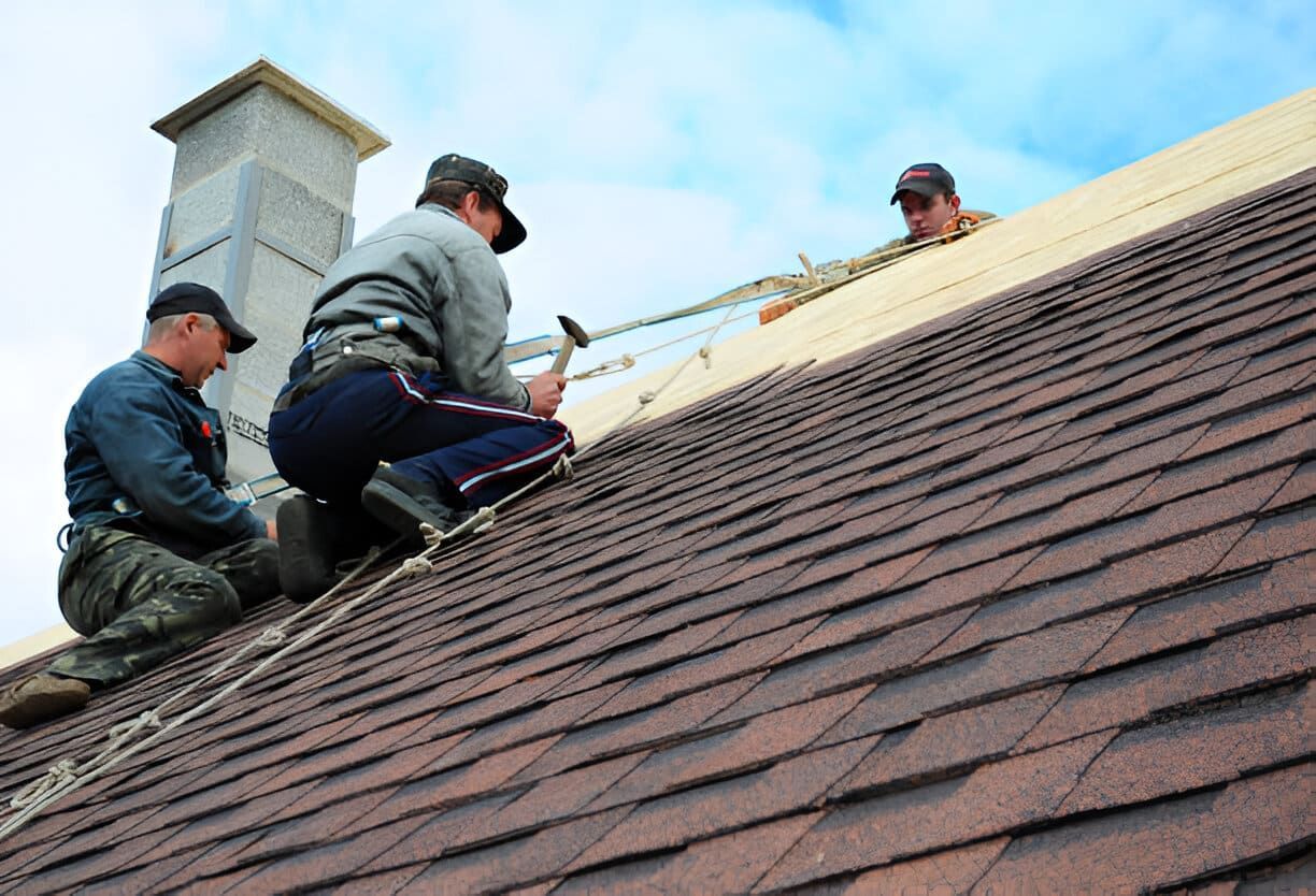 A group of men are working on a roof.
