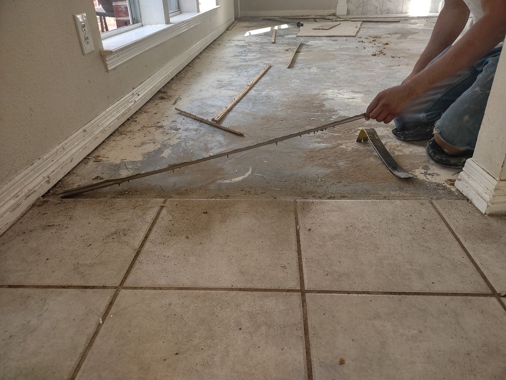 A person is measuring a tile floor with a tape measure.
