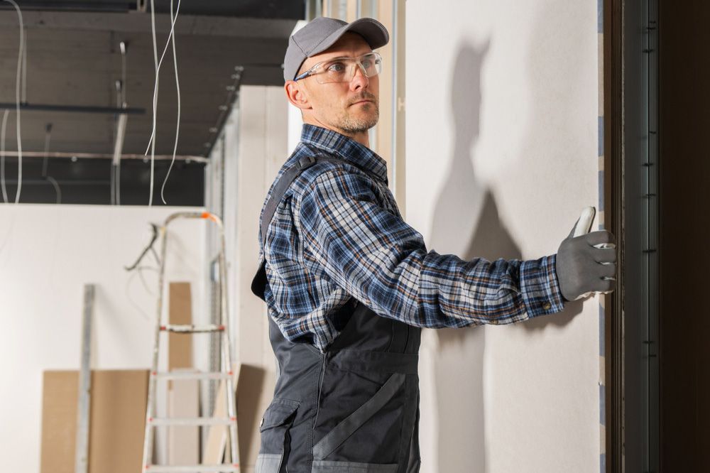 A man is working on a wall in a building.