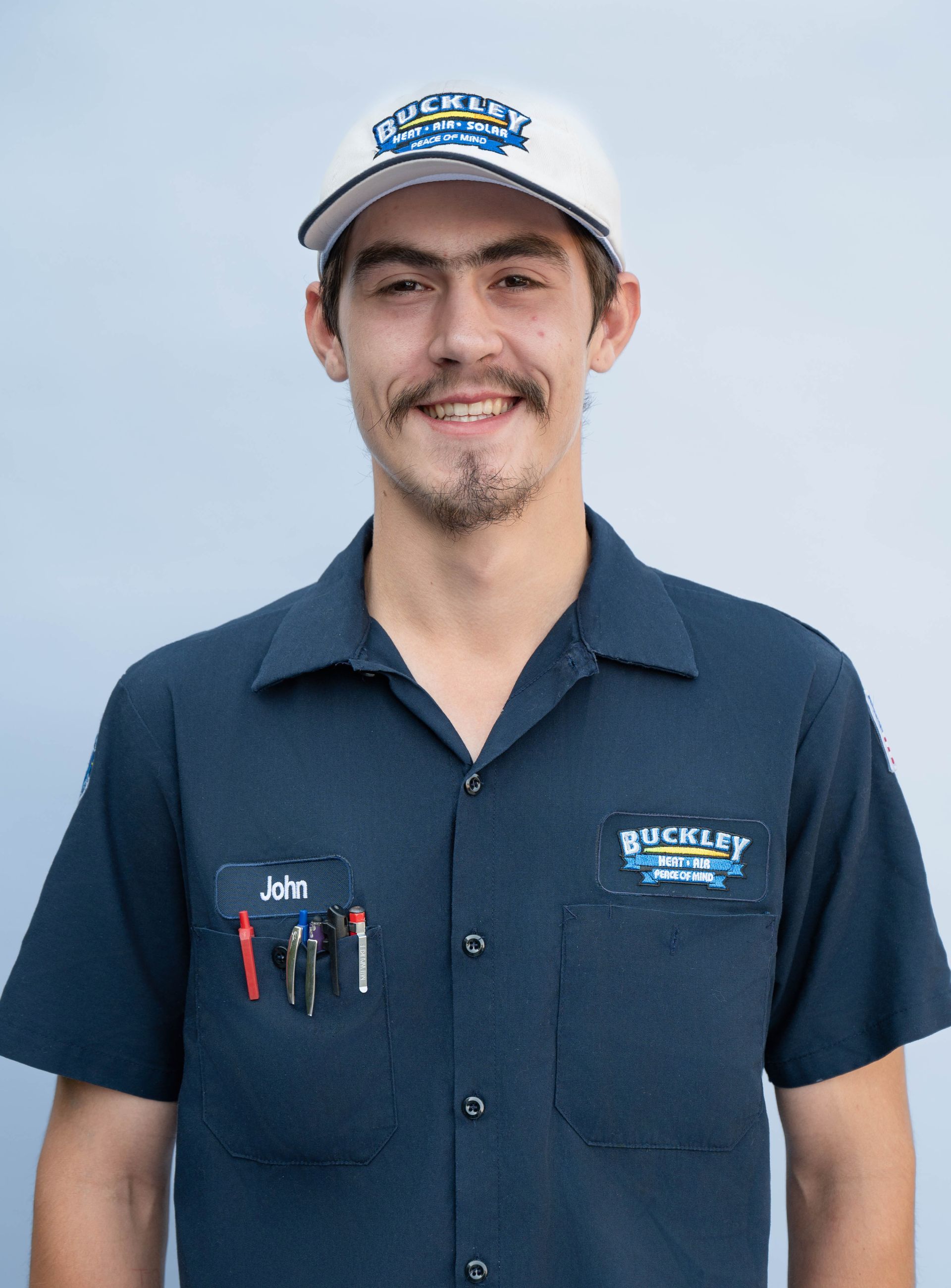 A woman wearing a blue polo shirt is smiling for the camera.