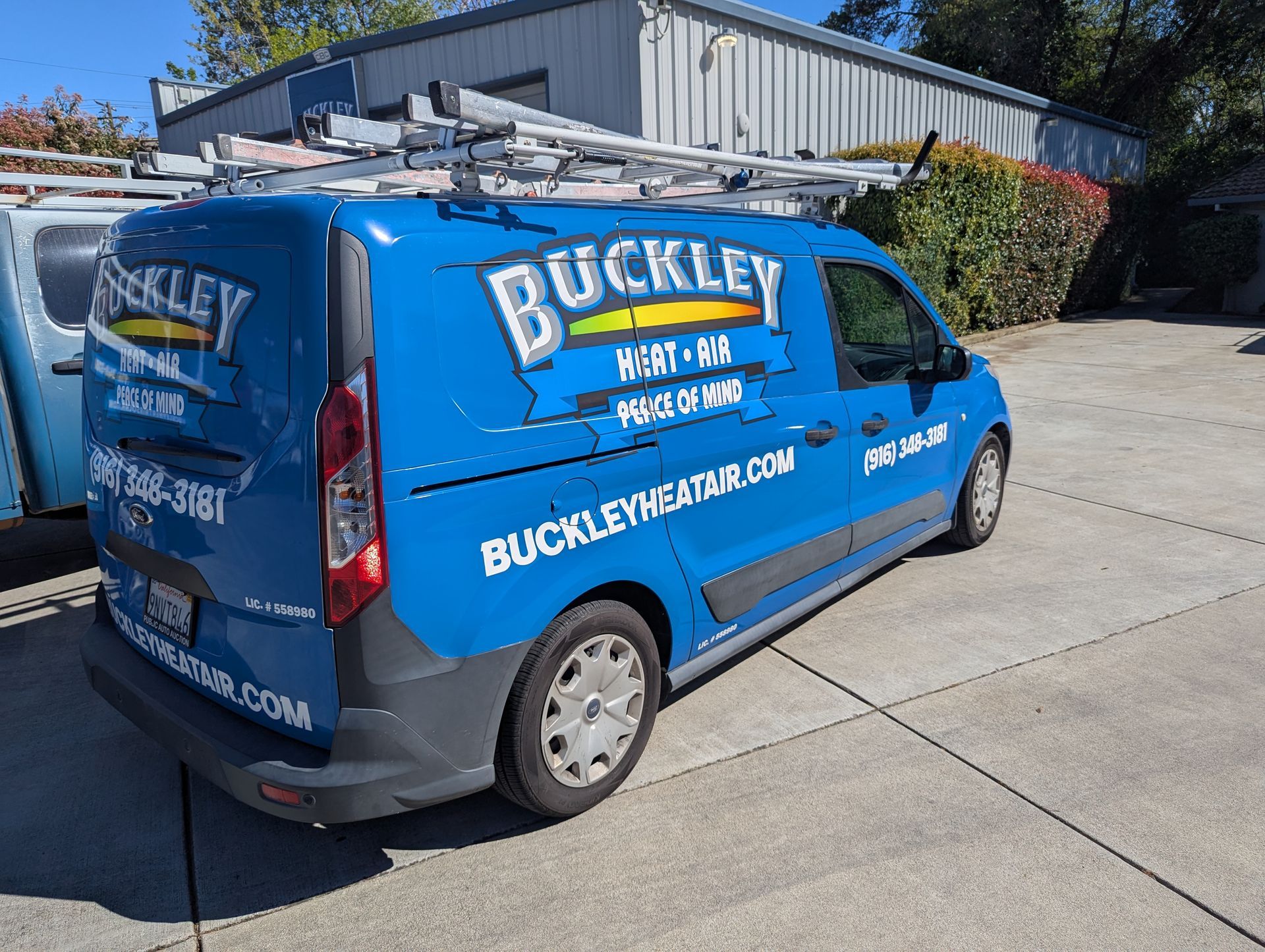 Two buckley trucks are parked in front of a building