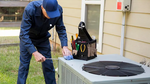 A man is working on an air conditioner outside of a house