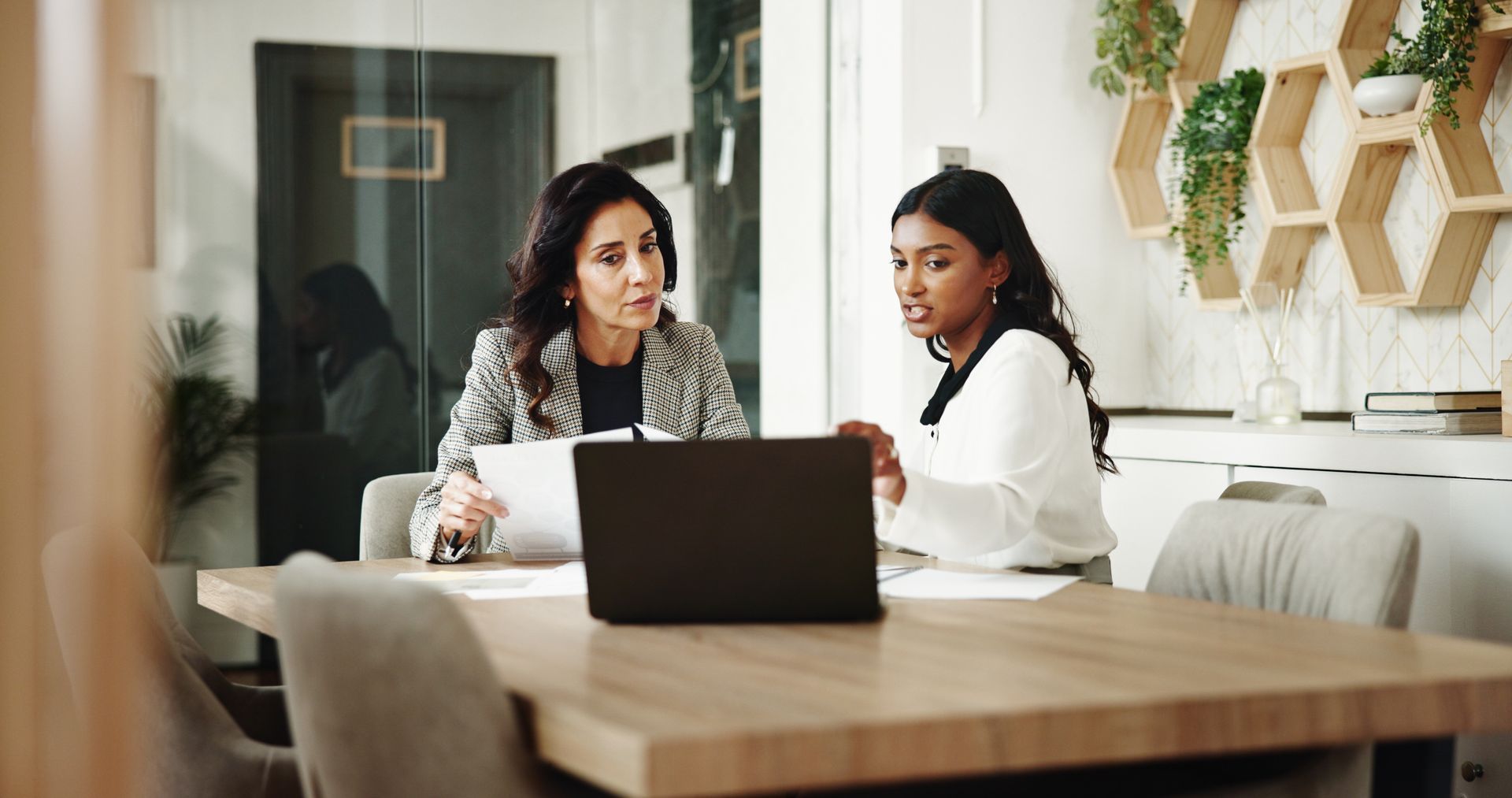 Two women are talking in a business meeting.