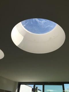 Een rond dakraam in het plafond van een kamer