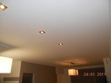 Een wit plafond met een paar lampen erop in een kamer.