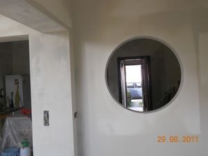 Er zit een rond gat in de muur dat op een raam lijkt.