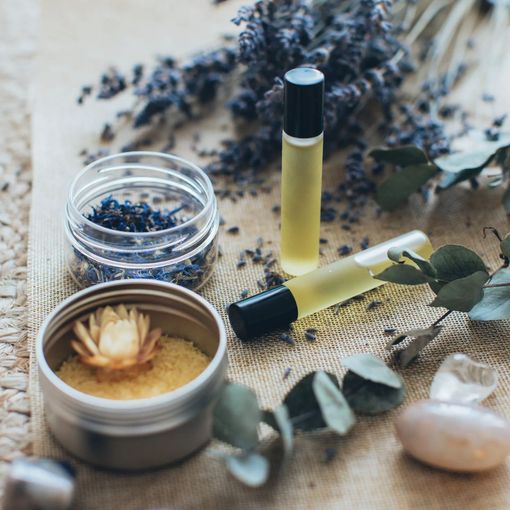 a table topped with bottles of essential oils , flowers , and crystals .