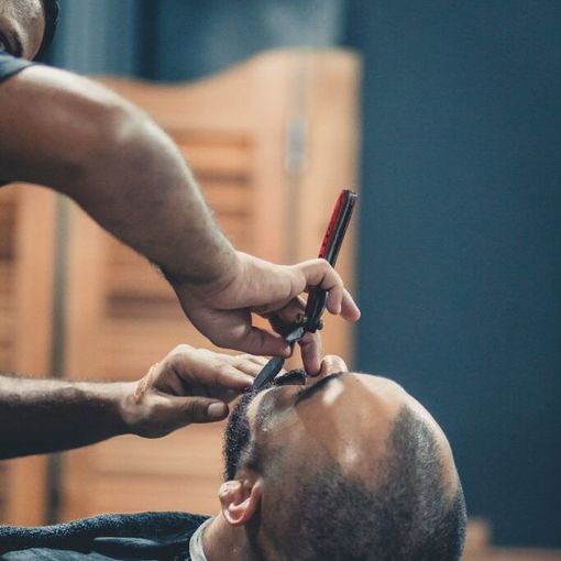 a man is getting his beard shaved by a barber .