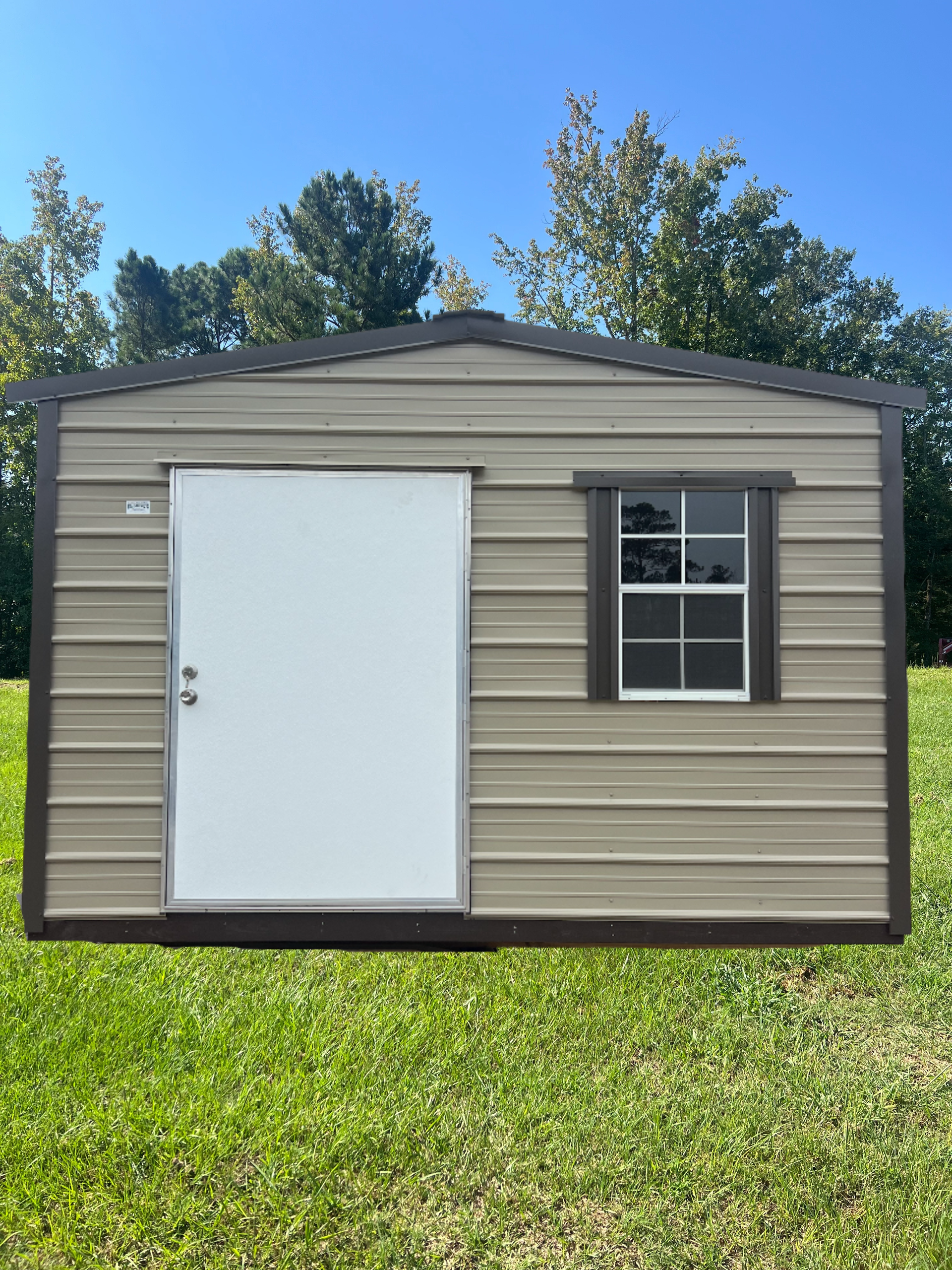 Tan metal storage shed with roll-up door, under a cloudy sky.